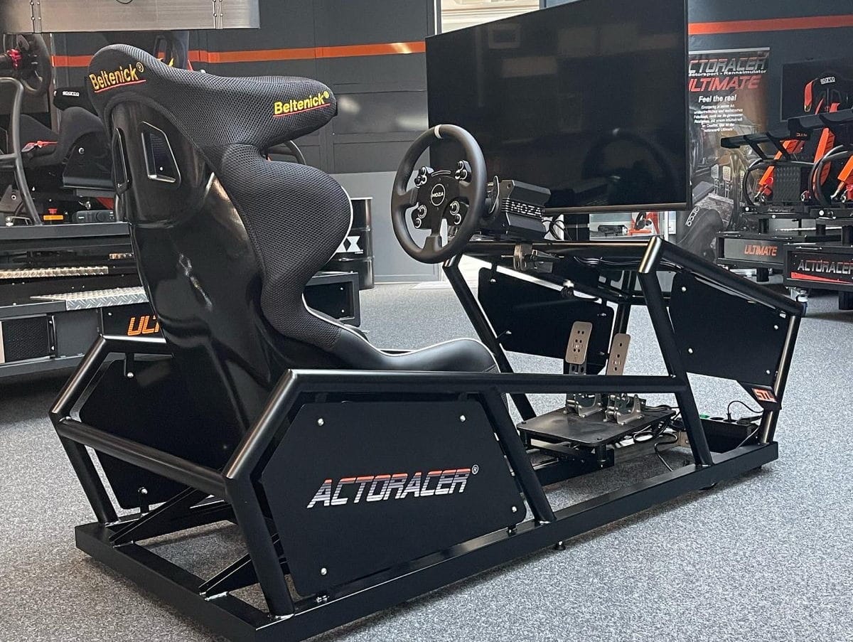 The racing simulator Actoracer Mini from STL Mini with black tubular frame, large monitor, racing steering wheel and racing seat from Beltenick.